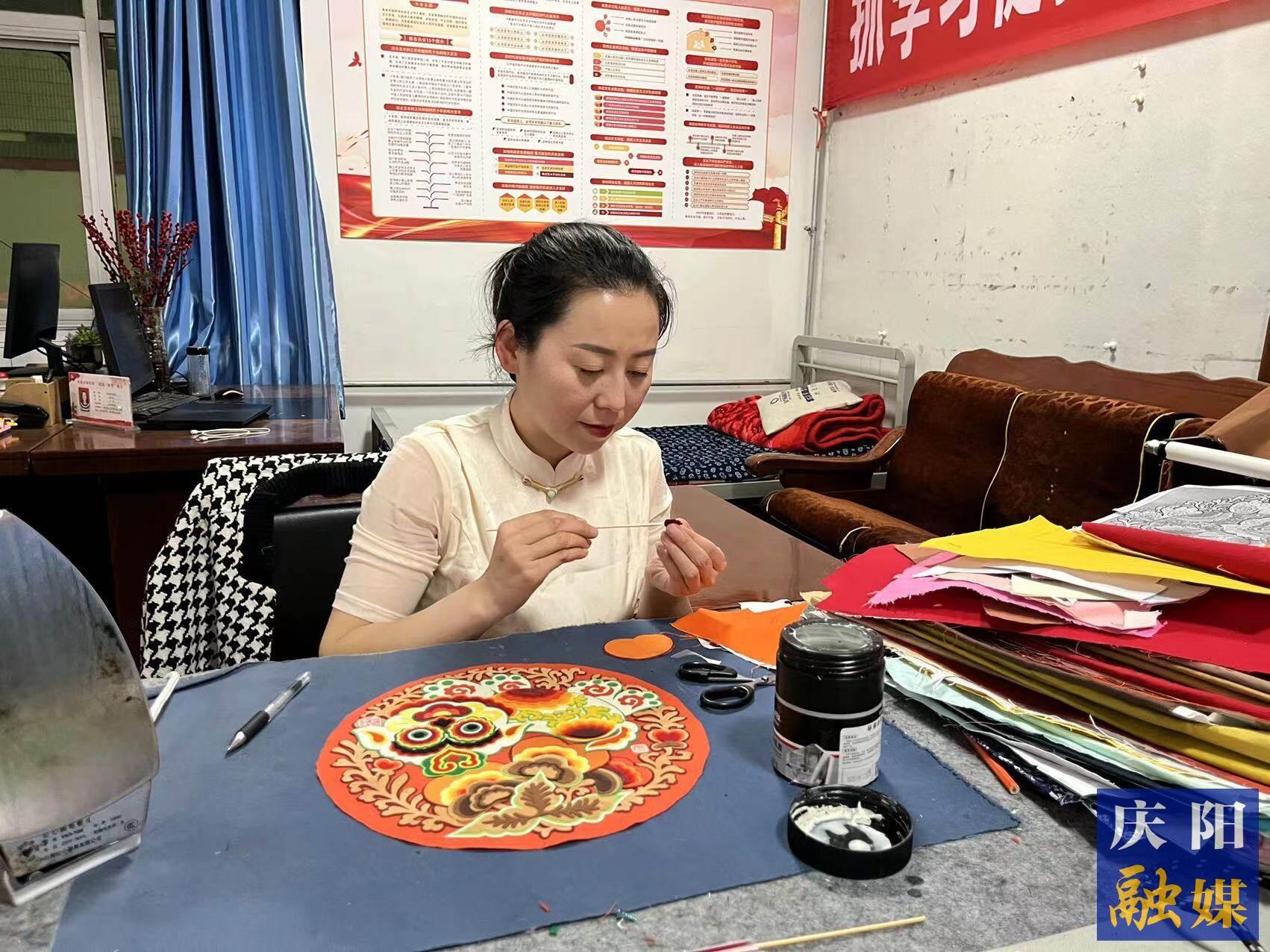 李慶英正在創(chuàng)作布貼畫作品。